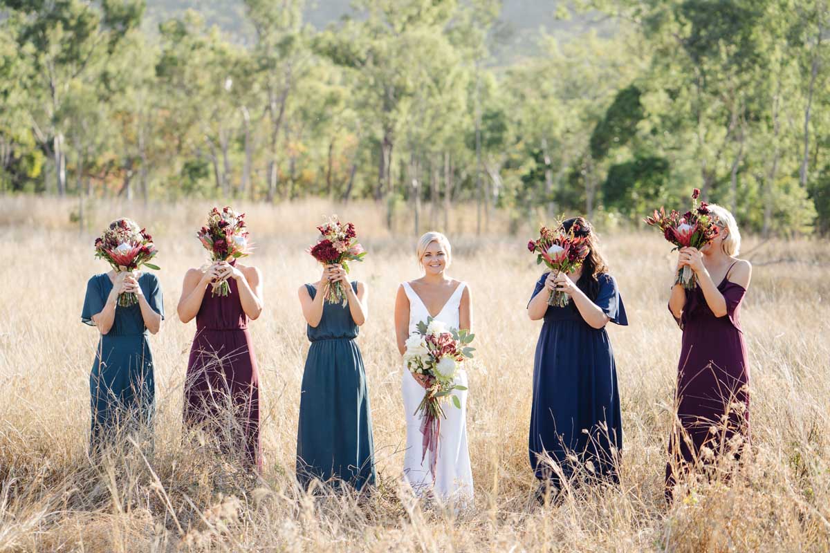 Cheeky bridesmaid photo with flowers in front of their faces
