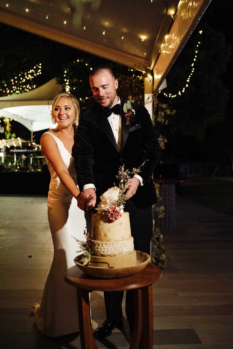 Bride and groom cutting the wedding cheese wheel cake